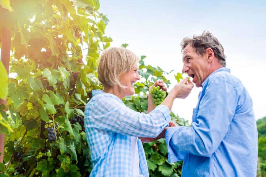 a man and a woman eating grapes
